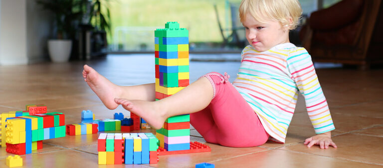 Kind auf Fliesboden im Kinderzimmer